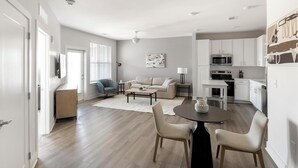 A modern apartment with a living room, dining area, and kitchen. - Landing | Chic 1BD, Courtyard, Yoga Studio (Huntsville)