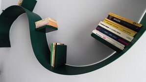 Une bibliothèque moderne, avec une variété de livres et une petite pile de papiers.