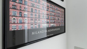 A framed artwork depicting a street view of Milan's Montepolo area, with buildings and storefronts. - Italianway Comfort - Copernico 47 B (Milan)