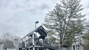 Une aire de jeux avec un toboggan et une structure d’escalade.