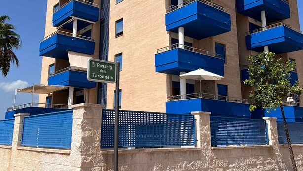 A multi-story building with blue balconies, a sign indicating 'Pesseig Tardongers', and a gated entrance. - Apartment in Playa de Piles ( Valencia ) 3 min from the beach (VC)
