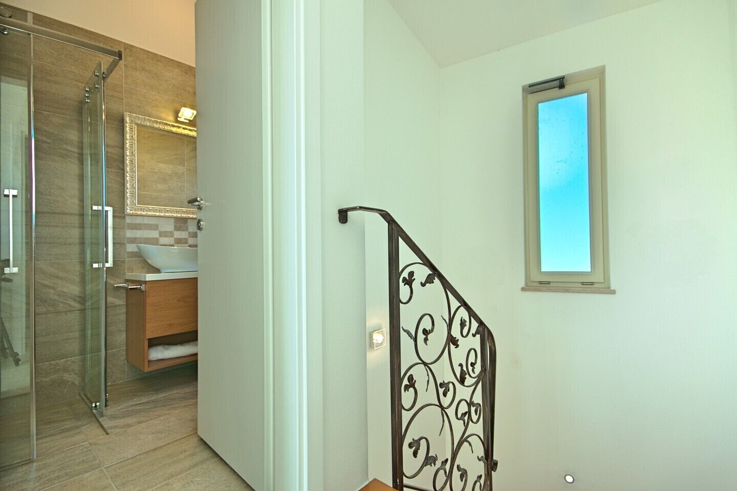 A bathroom with a glass shower enclosure, a sink, and a toilet.