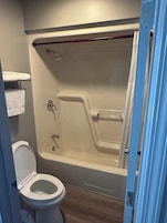 Bañera con ducha, toallas, jabón, shampoo