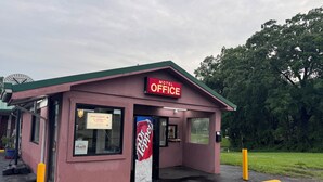 A pink building with a 'Hotel Office' sign, a Dr Pepper sign, and a 503 address number. - David Crockett Motel (Lawrenceburg)