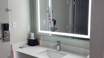 Een bad/douchecombinatie, handdoeken, zeep, shampoo