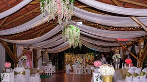 An indoor venue with a bamboo structure, white draped ceilings, and tables set for an event. - Hotel Mar Azul Neiva (Neiva)