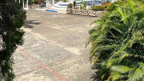 A paved pathway leading to a building with a blue roof, surrounded by lush greenery and palm trees. - Hotel Mar Azul Neiva (Neiva)