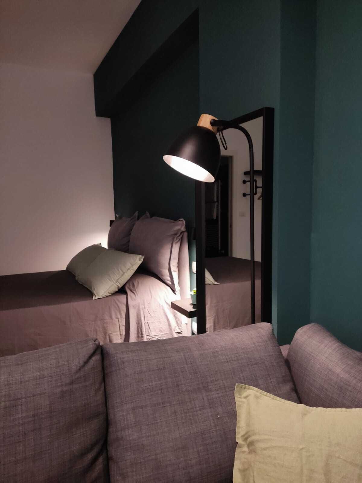 A room with a bunk bed, a desk, and a lamp.