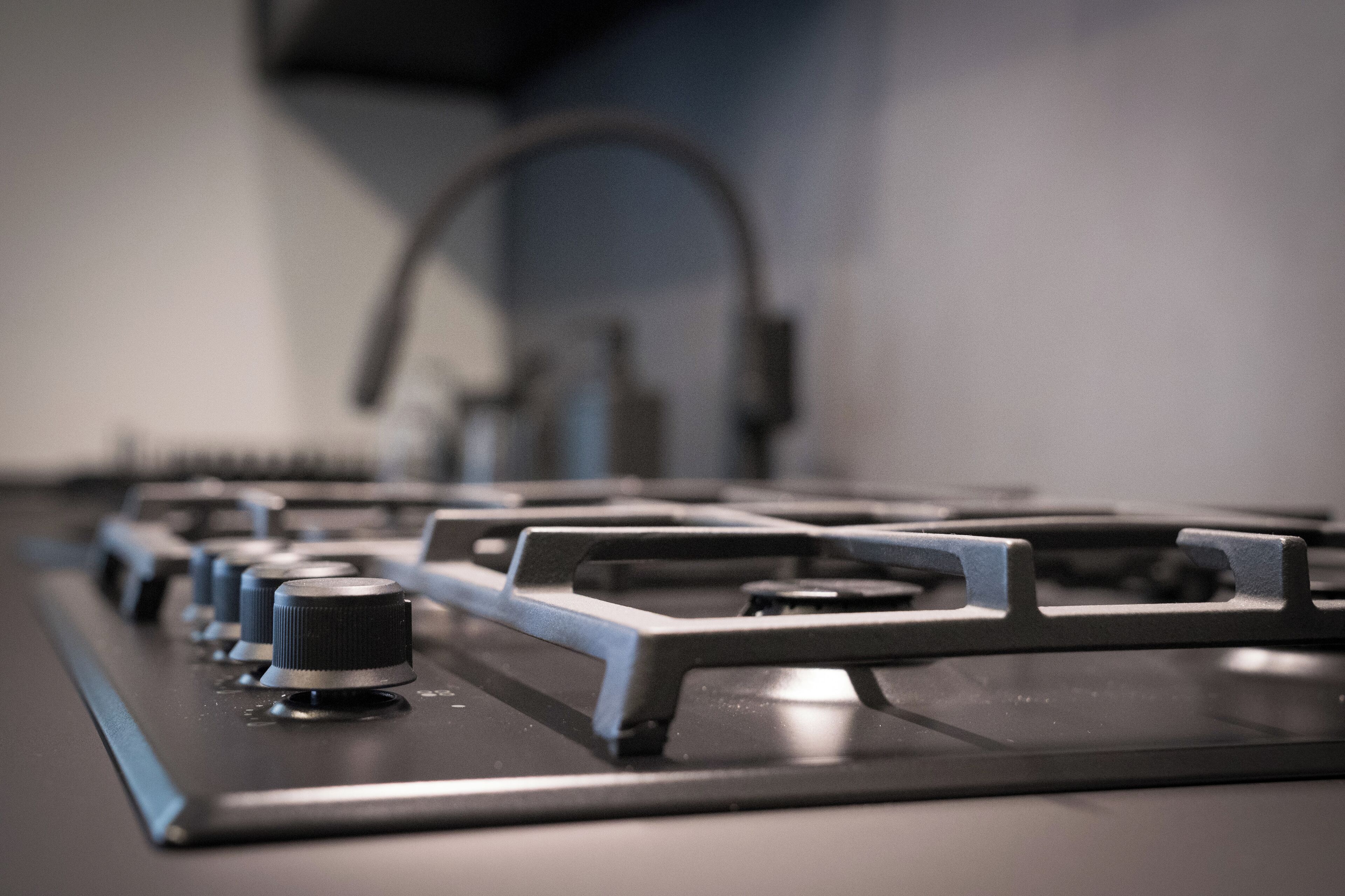 A close-up of a gas stove with knobs and burners.