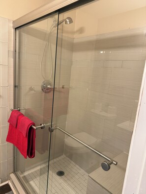 Een douche, handdoeken, zeep, toiletpapier