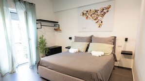 Una camera da letto moderna con un letto grande, comodini, un'opera d'arte a parete e una pianta in vaso.