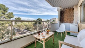 A balcony with a table, chairs, and a view of the cityscape. - Bambu Salou / Tropical / Chill out / Pool / Wifi (Salou)