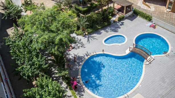 A rooftop pool with two smaller pools and a bridge, surrounded by greenery and buildings. - Bambu Salou / Tropical / Chill out / Pool / Wifi (Salou)