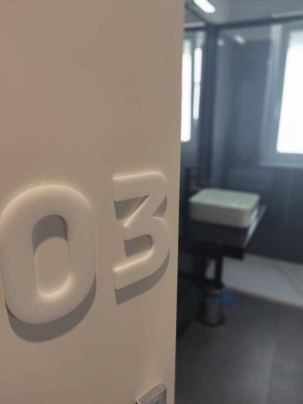 A room with a door labeled '03' and a window with a view of a building outside.
