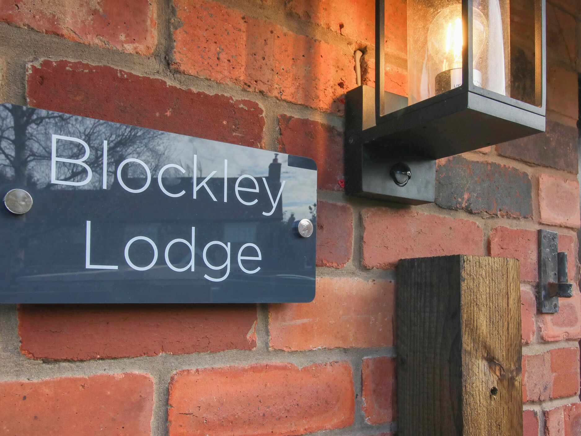 A brick wall with a sign that reads "Blockley Lodge."