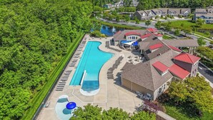 A residential area with a swimming pool, a water slide, and houses with red roofs.
