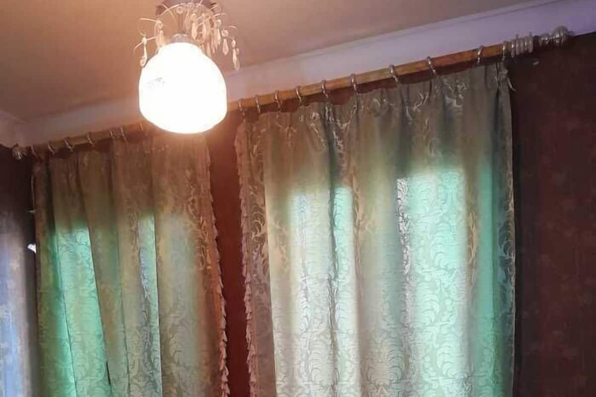 Ein Hotelzimmer mit einem Bett, einem Heizkörper und Vorhängen.