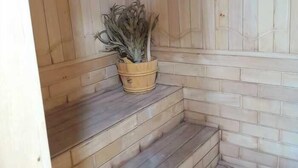 Een houten trap met een bloempot op de overloop.