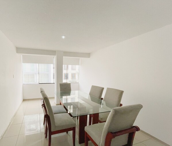 Conference room with a glass-top table and four chairs, ideal for meetings and presentations.