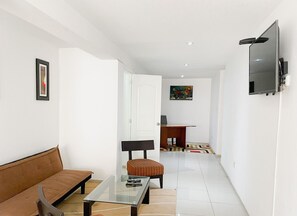 Relax in this stylish living area with a leather sofa, armchair, and flat-screen TV.