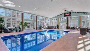 Una piscina interior con vistas al exterior, un ventilador de techo y el logo de Netflix.
