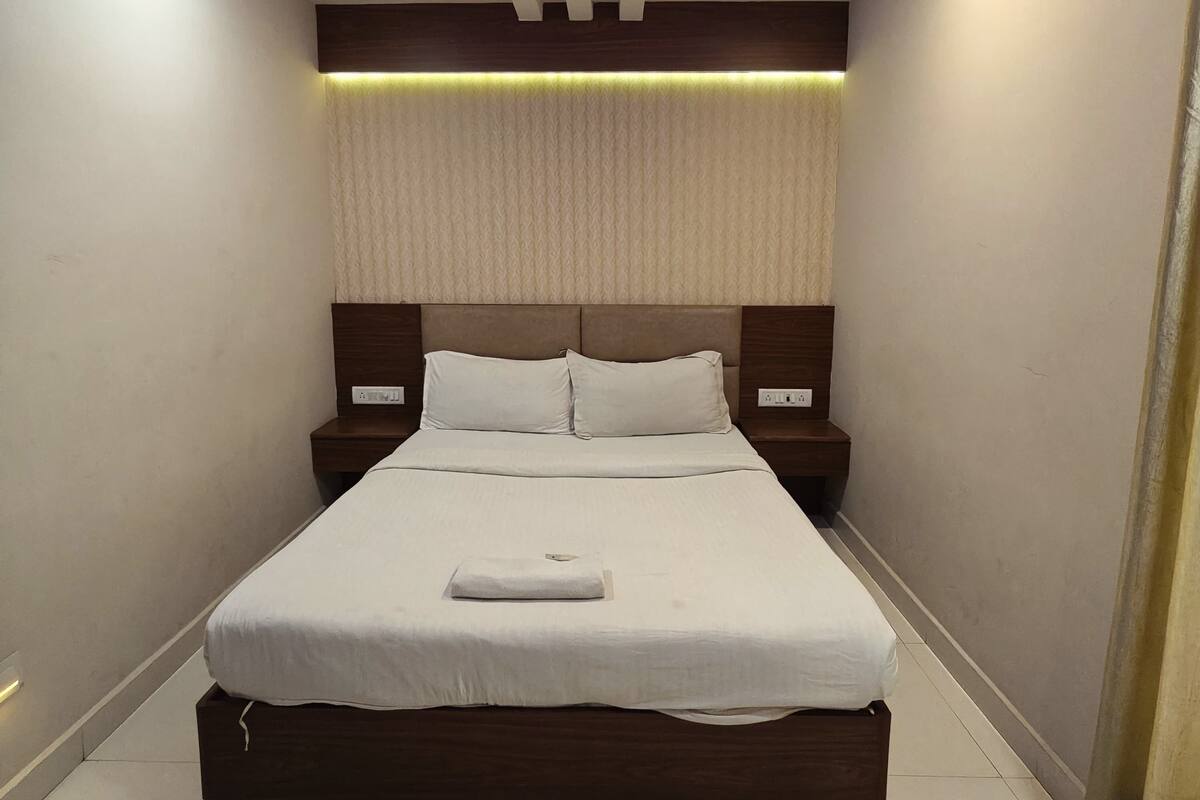 A modern bedroom with a bed, nightstands, a ceiling fan, and recessed lighting.