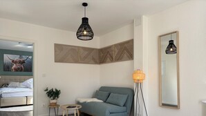 A modern living room with a grey sofa, a round rug, a small wooden table, and a floor lamp. - Relax in the heart of the Eifel - vacation apartment with huge roof terrace (Hellenthal)