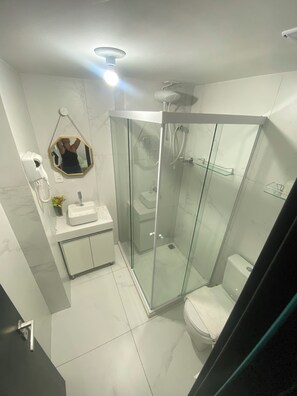 Een douche, handdoeken, zeep, toiletpapier