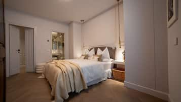 A bedroom with a bed, bedside table, lamp, and a mirror.