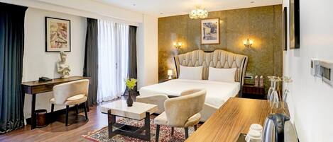 A hotel room with a bed, a desk, a chair, a coffee table, and a rug.
