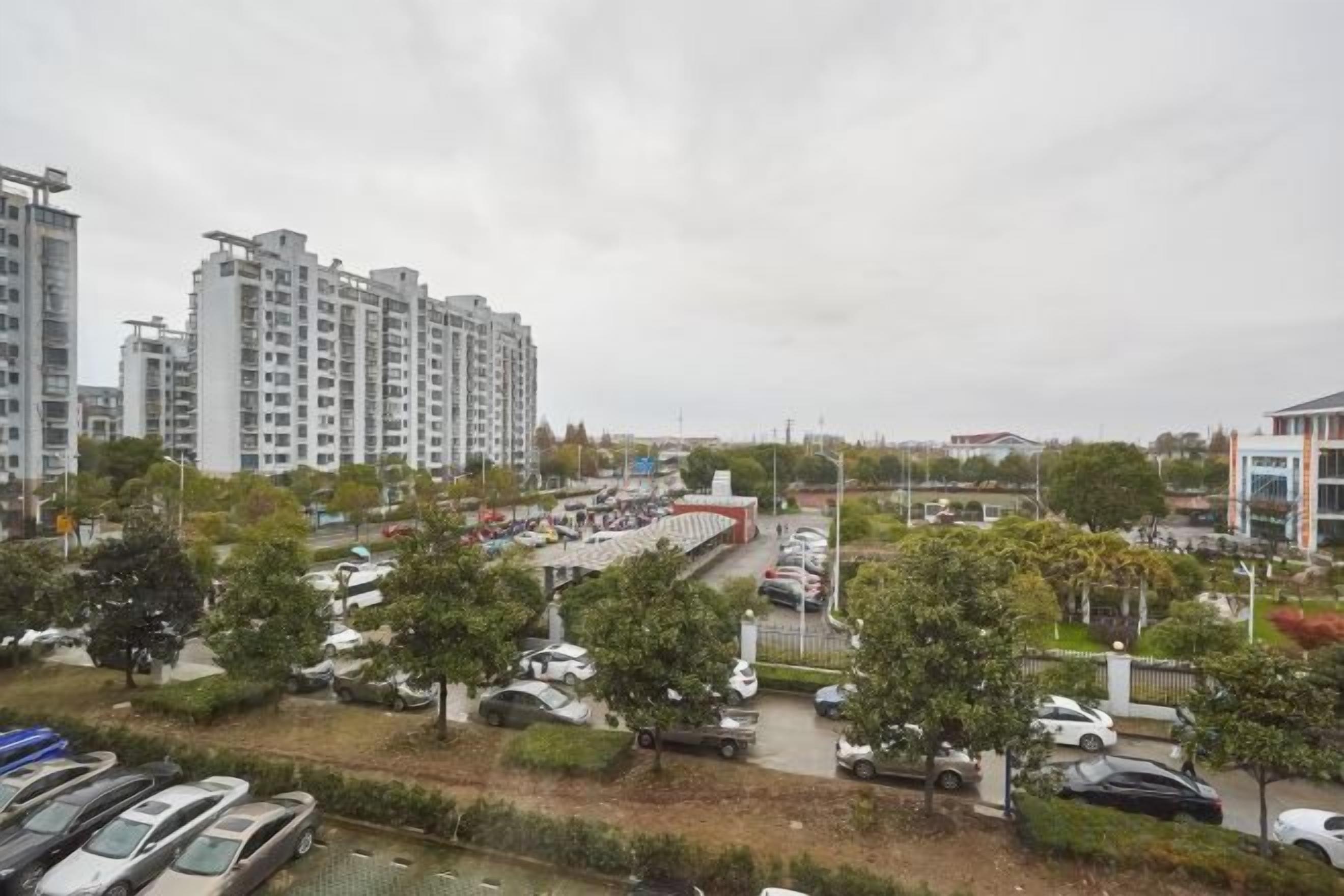 A residential area with multi-story buildings, a parking lot, and a bridge.