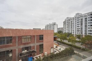 Un immeuble à plusieurs étages, doté d’une façade en briques et de grandes fenêtres.