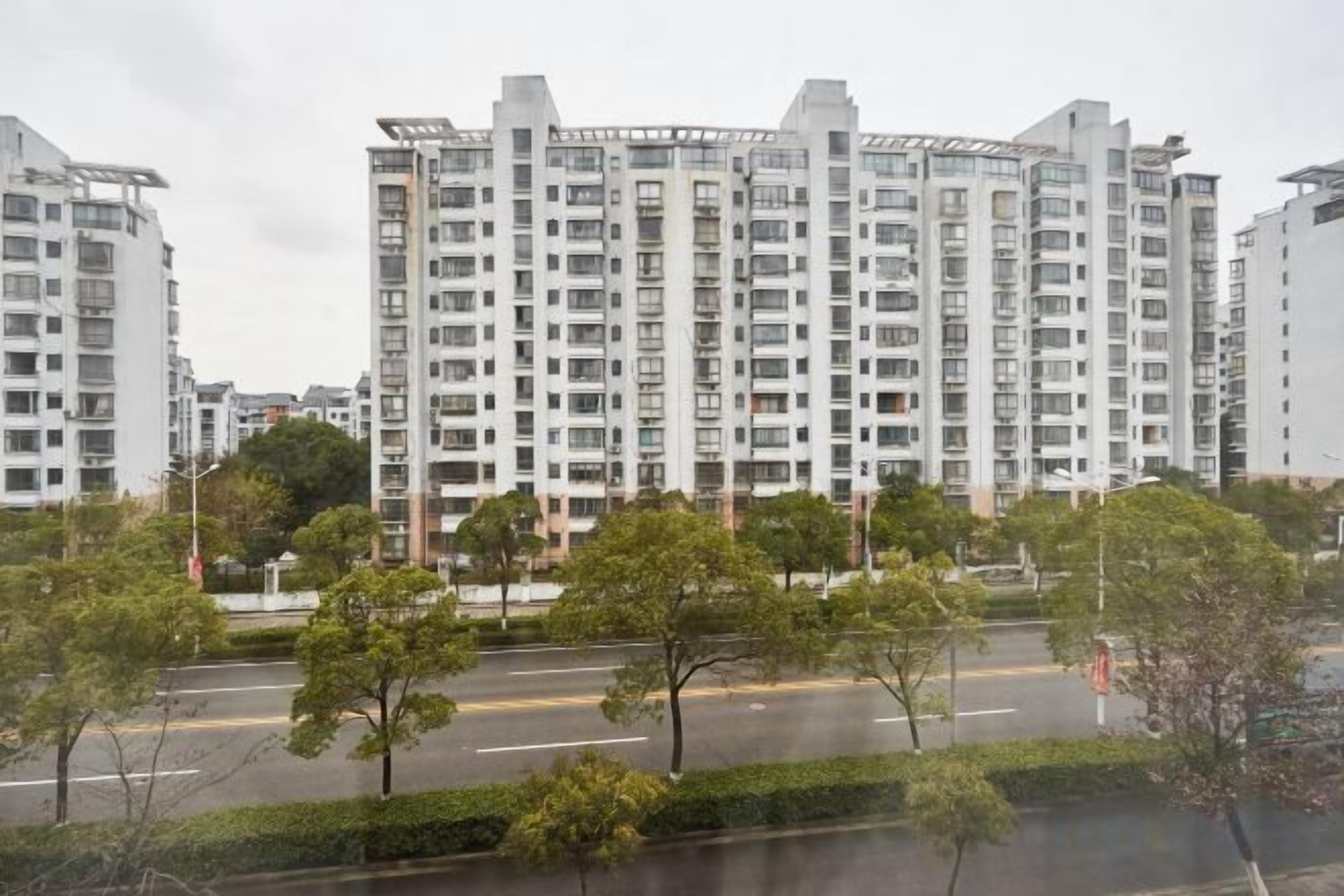 Un edificio residencial de varios pisos con un diseño arquitectónico moderno, que cuenta con balcones y una fachada uniforme.