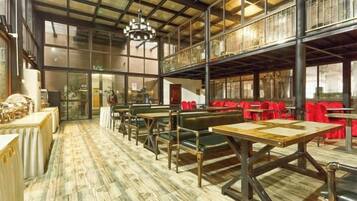 A spacious restaurant with high ceilings, exposed beams, and a mix of seating including tables and booths.