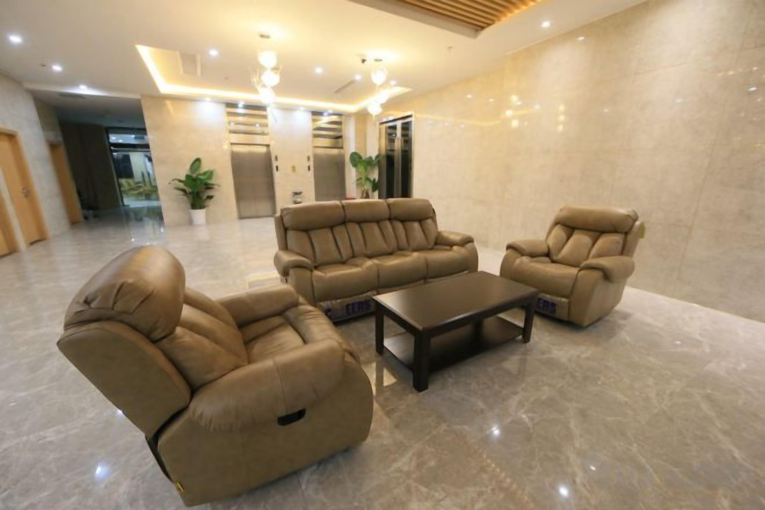 A modern lobby with a seating area featuring leather sofas and a coffee table.