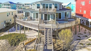 A multi-story house with a deck and a pool, surrounded by other colorful houses. - Dazzling Oceanfront Condo - Perfect for a Couples Getaway! By Williamson Realty (Ocean Isle Beach)