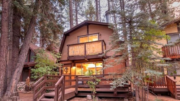 Eine Holzhütte mit Balkon und einer Treppe zum Eingang.