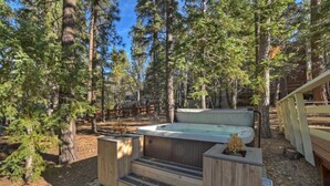 A hot tub in a forested area with wooden steps leading up to it. - Peaceful Sunshine Chalet with Hot Tub (Big Bear)