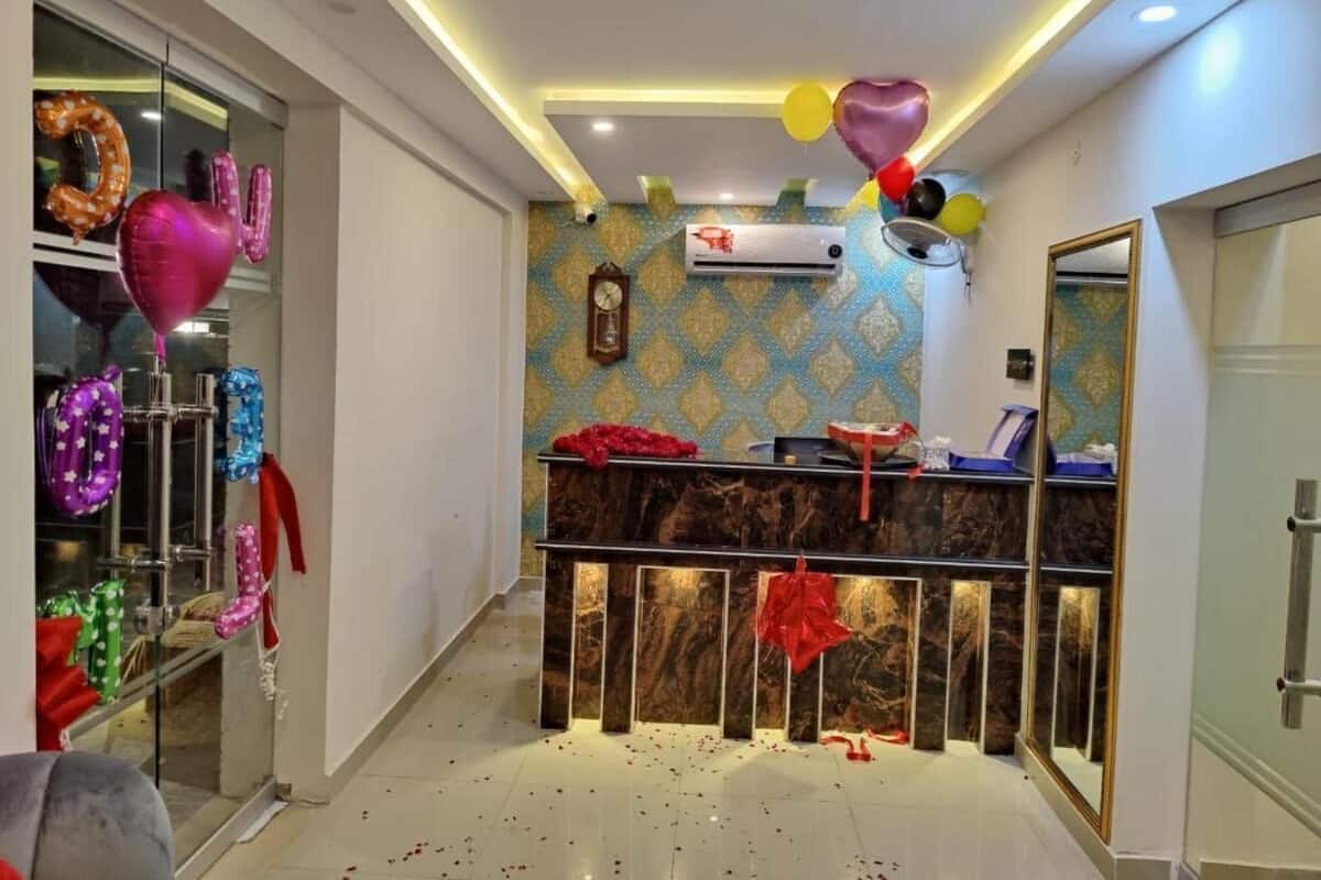 A reception area with a marble counter, decorative balloons, and a patterned wall.