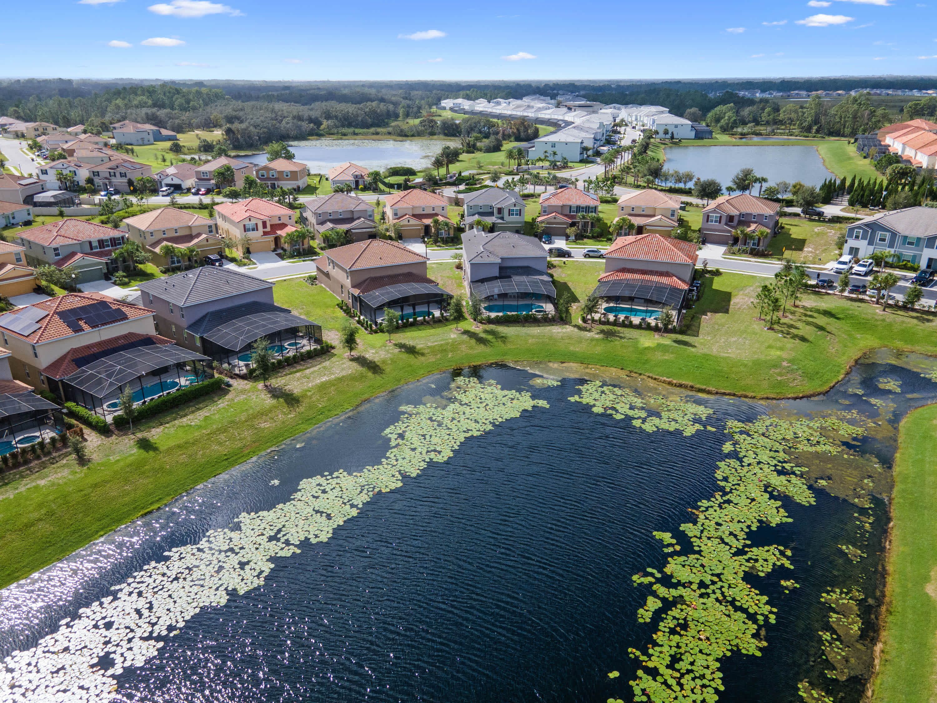A residential area with houses, a lake, and a golf course in the background.