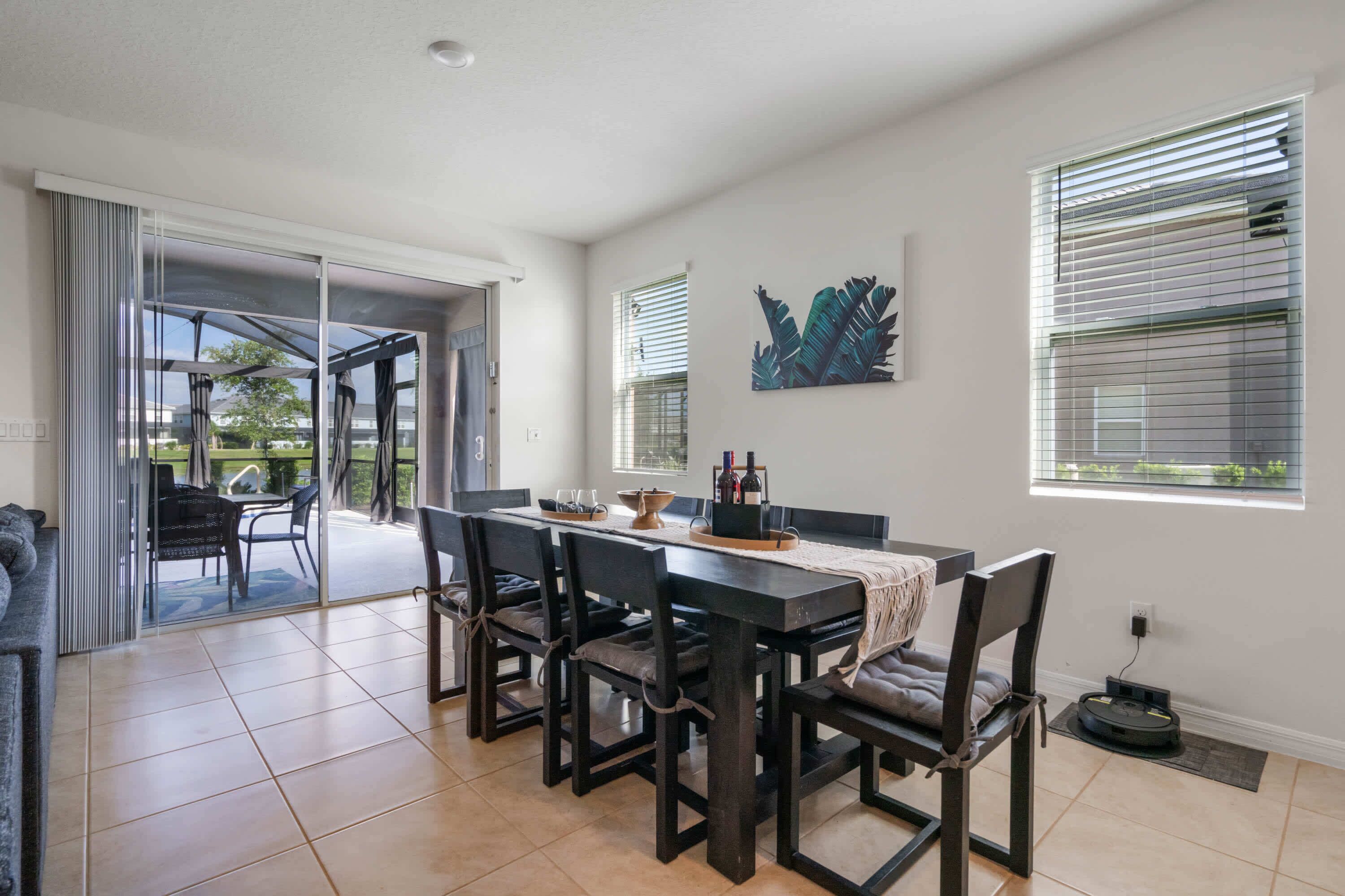 A dining area with a table, chairs, and a view of the outdoors.