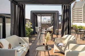 A rooftop terrace with outdoor seating, a pergola, and a city view. - ULIV Pulse Roma - Condesa (Mexico City)