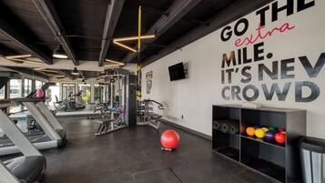 Ein Fitnessstudio mit Laufbändern, Trainingsgeräten und einem motivierenden Zitat an der Wand.