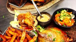 A meal consisting of roasted chicken, fries, and a salad with a dipping sauce.