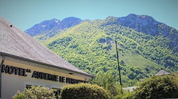 A hotel named "HOTEL AUBERGE LE PERMAVOIR" with a view of a mountainous landscape.
