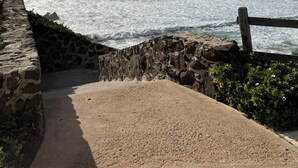 Rantaviertä kulkeva kävelyreitti, jolta avautuu näkymä merelle, ja reitin varrella on kivimuureja sekä puinen aita.