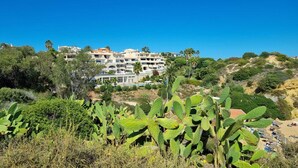 A multi-story hotel with balconies, surrounded by greenery and cacti. - NEW apt. 1 min. walk from beach, sea view, large terrace, two pools (Albufeira)