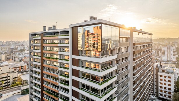 Um edifício alto com várias varandas, janelas amplas e design arquitetônico moderno.