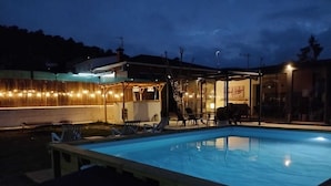 A swimming pool with lounge chairs and a covered patio area.