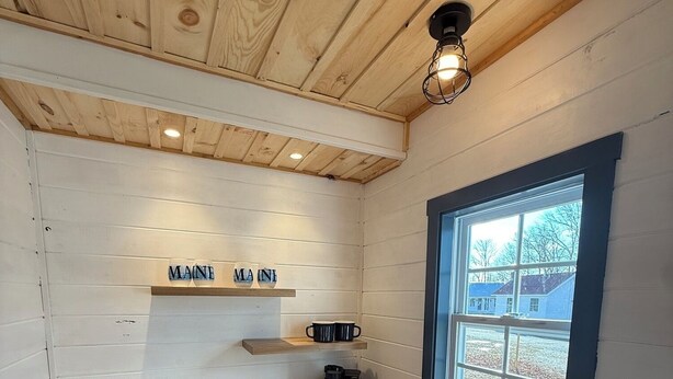 A kitchen with a wooden countertop, a sink, and a window with a view of houses. - Eden Village Cottage 6 in Bar Harbor, minutes to Acadia & Downtown, Sleeps 6. (Bar Harbor)